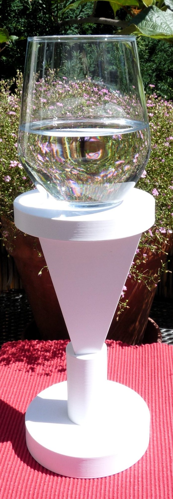 kraftvolle energetische Platform Die Podestpyramide steht umgedreht in einem Halter. Au ihrem Podest steht ein Glas mit Wasser das kraftvoll energetisiert wird.