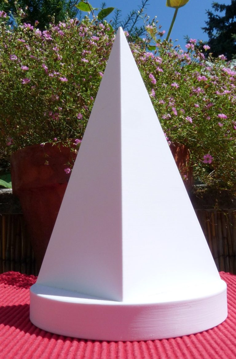 Pyramide Goldener Schnitt Weiße Pyramide Goldener Schnitt auf rundem Podest dahinter blühende Blumen